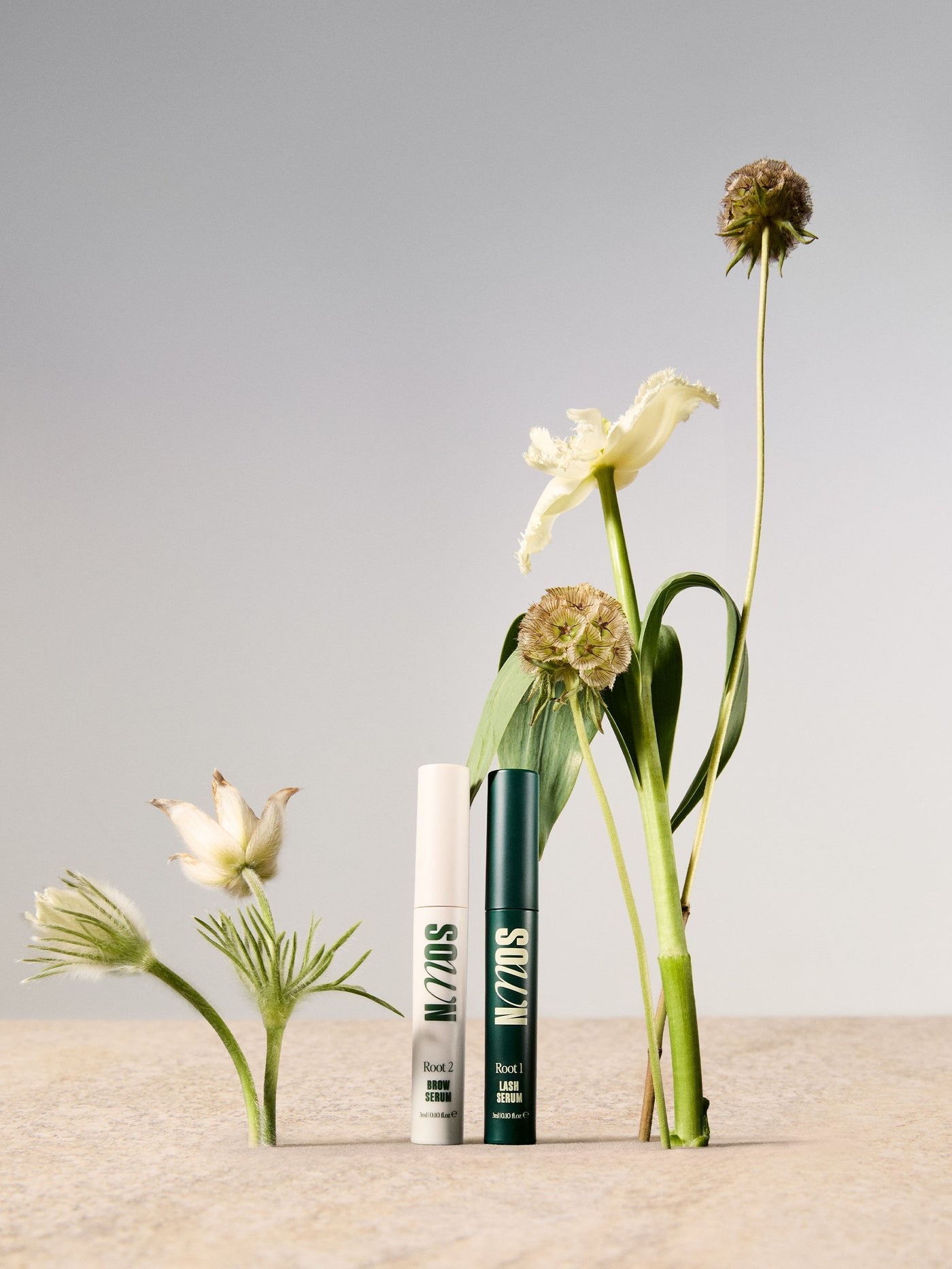 Root 1 Lash Growth Serum and Root 2 Eyebrow Growth Serum styled with dried flowers