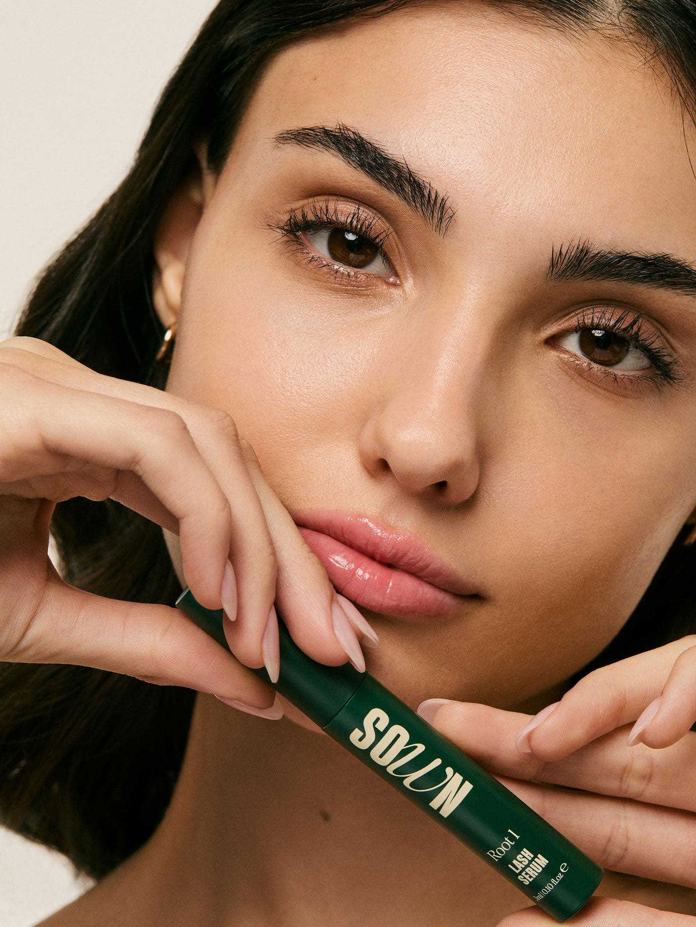 Root 1 Lash Growth Serum held beside the face